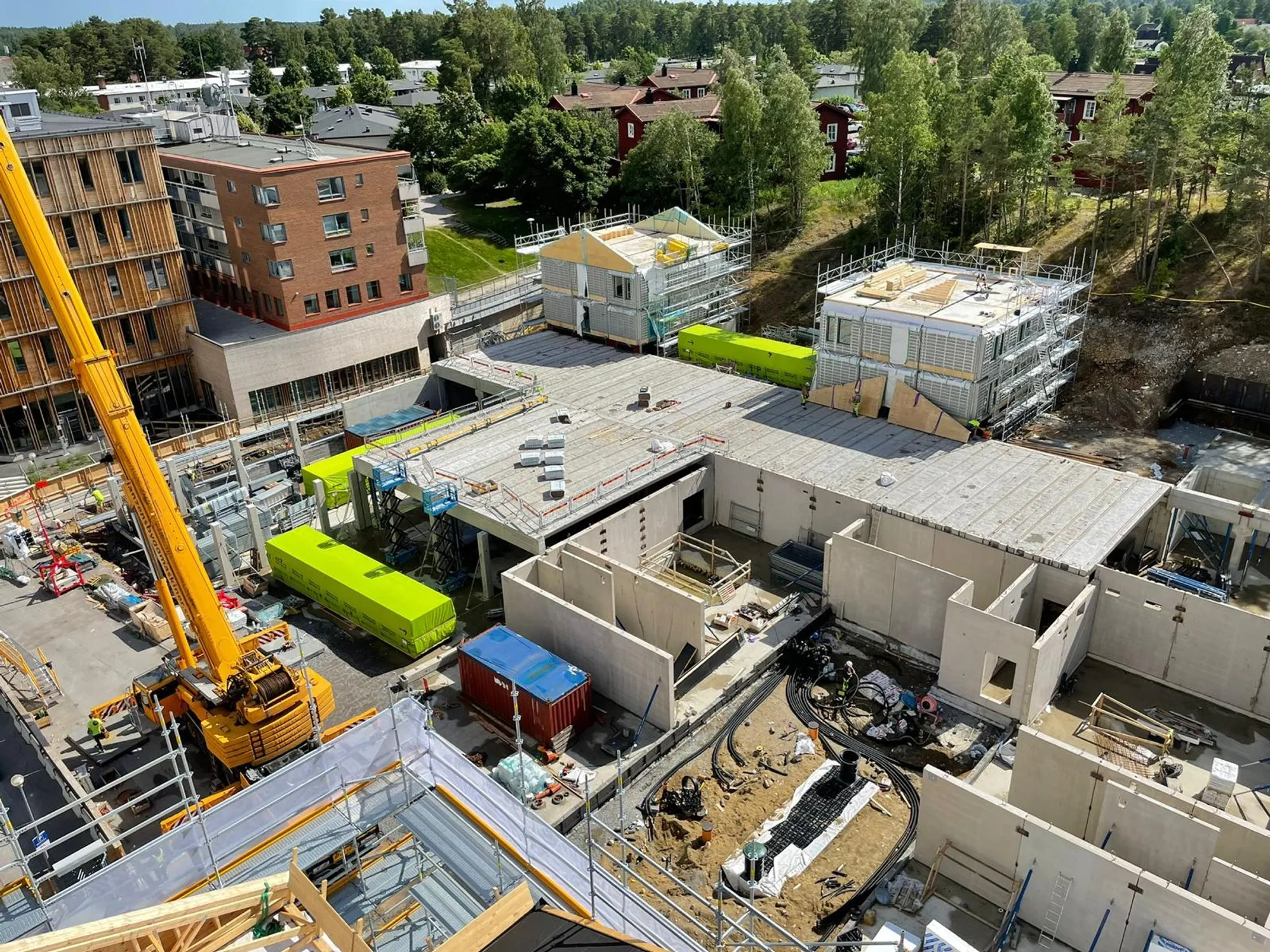 Bostadsprojekt under uppförande med betongstomme, prefabdelar och mobilkran